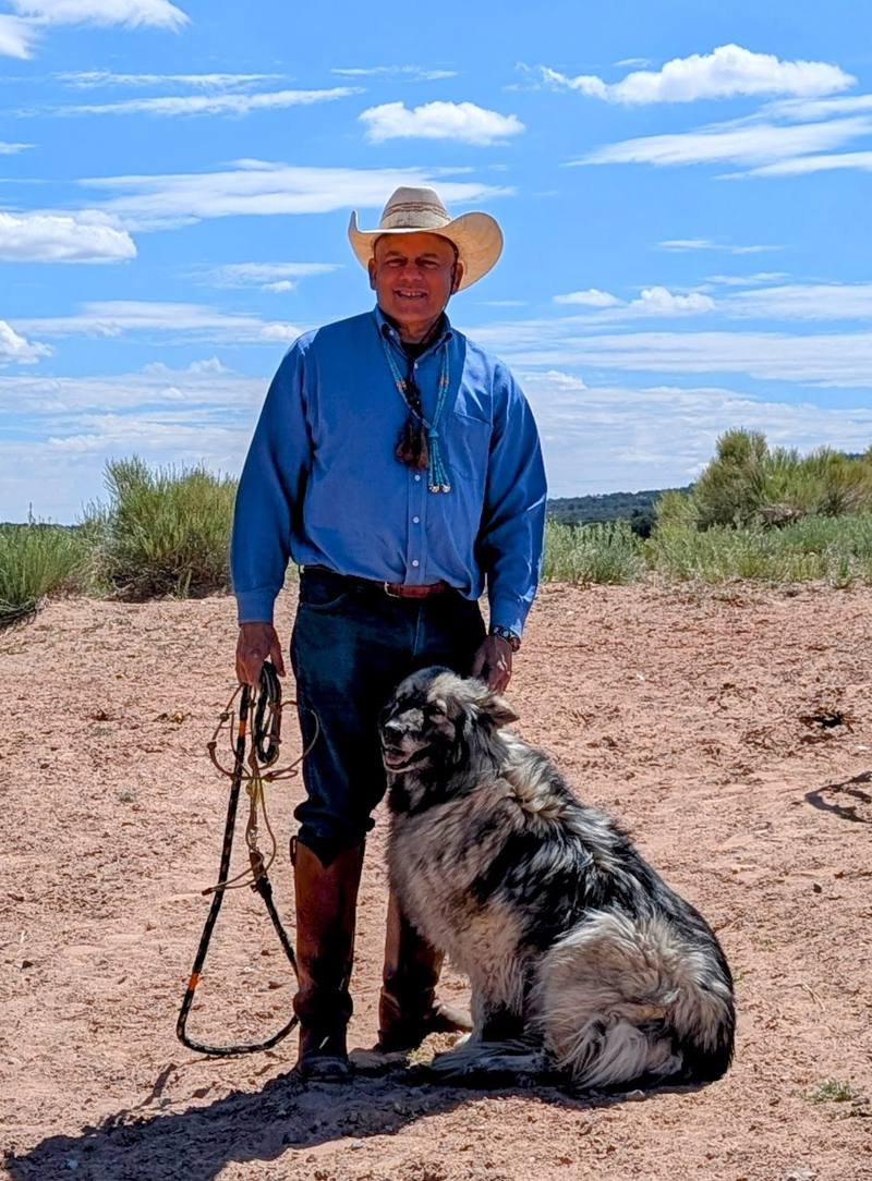 Paul D'Souza standing with his dog on the New Mexico high desert at Casa D'Souza Ranch
